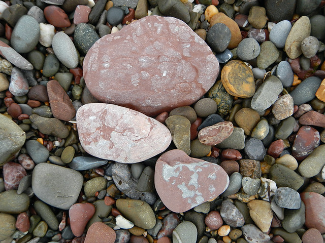 Faded red pebbles on the beach called Freshwater East in Wales