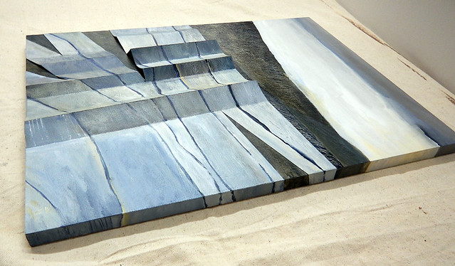 Painting of Stevns Klint, chalk cliffs on the east coast of Denmark from the side showing how the paint extends onto the side of the wood panel adding yet another 3D effect to the folded watercolour paper collaged onto the top surface