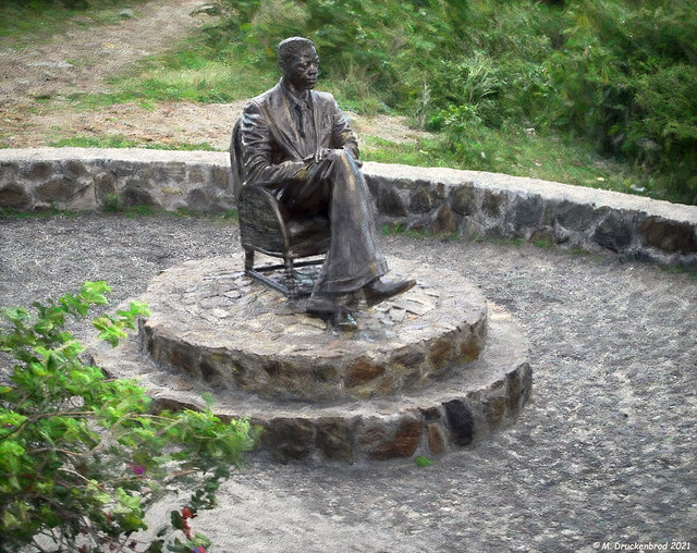 Man on chair Statue on top of Cole Bay Hill looking towards Cay Bay and the Caribbean Sea