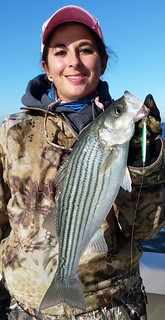 Photo of young woman holding a striped bass