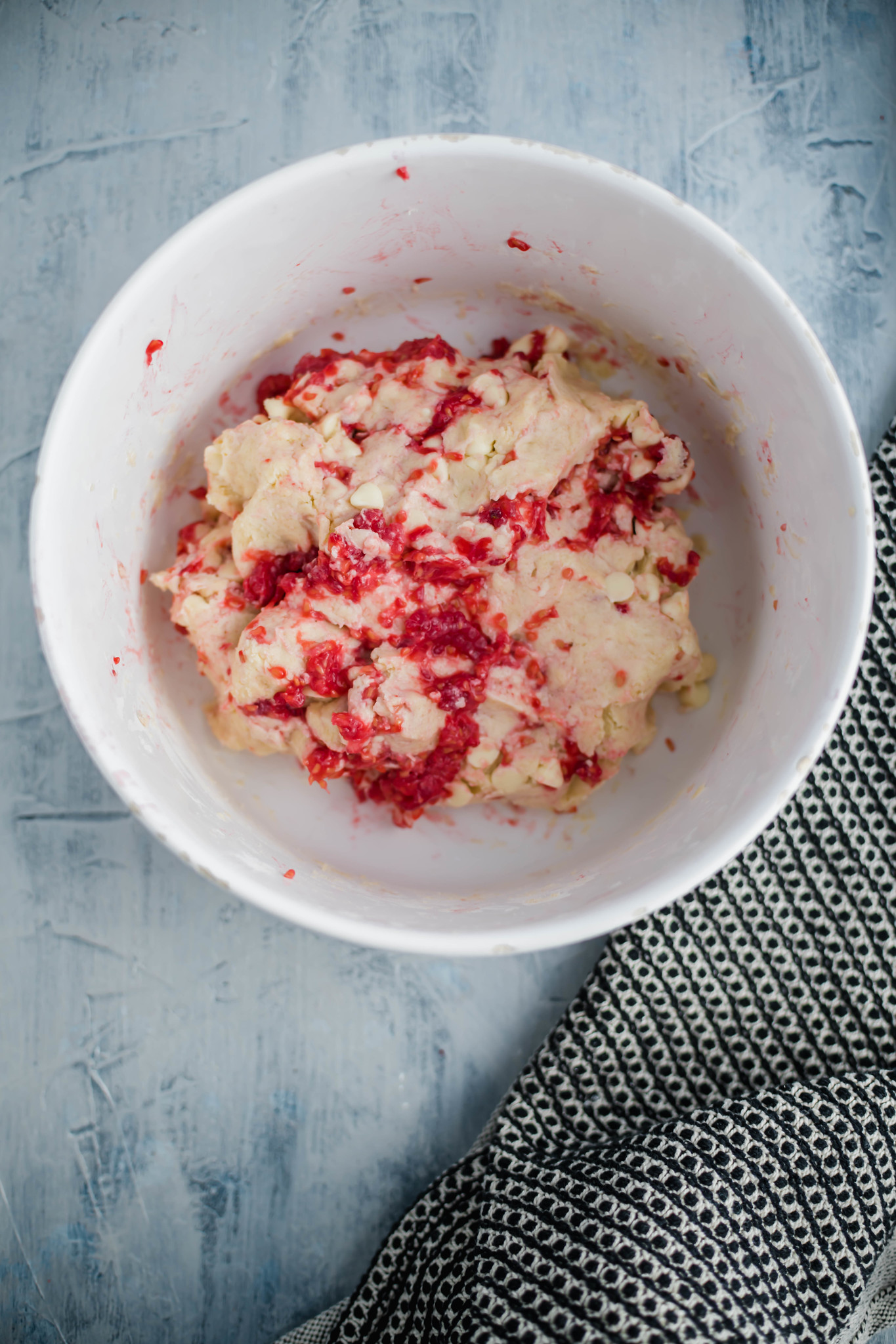Raspberry scone dough mixed together in a large white bowl.