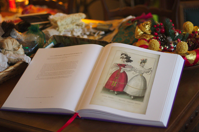 Les livre Fashion plates, ouvert sur une table, une couronne de Noël au second plan
