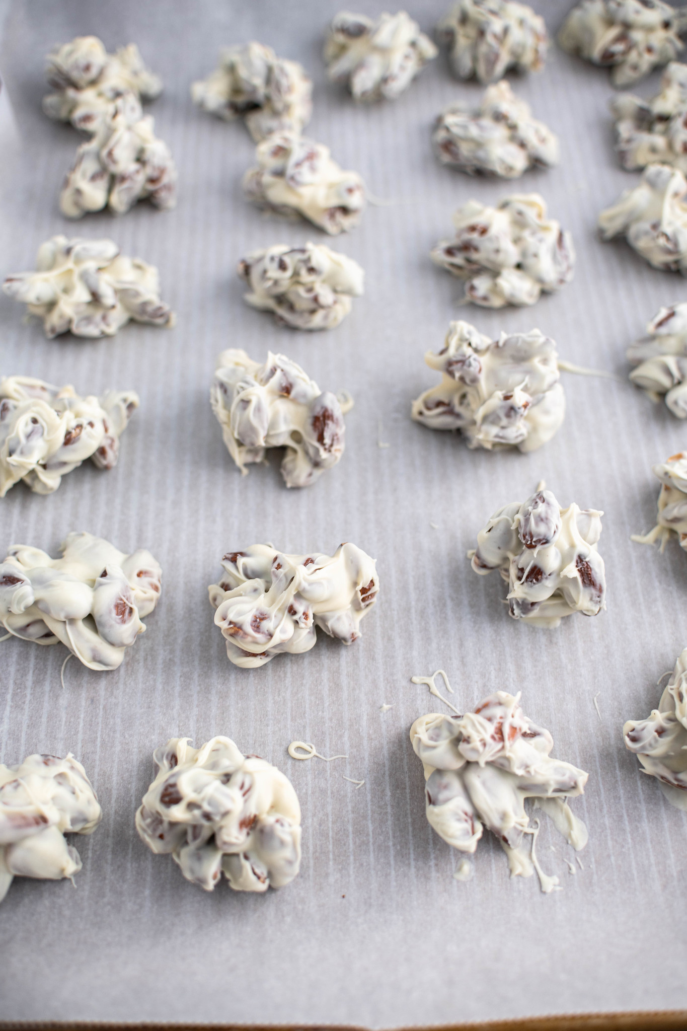 white chocolate almond clusters on parchment paper.