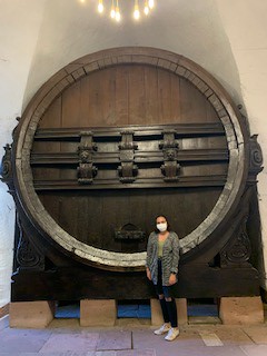 Trinidy, masked up, standing before the world's largest Wine barrel in Heidelberg.