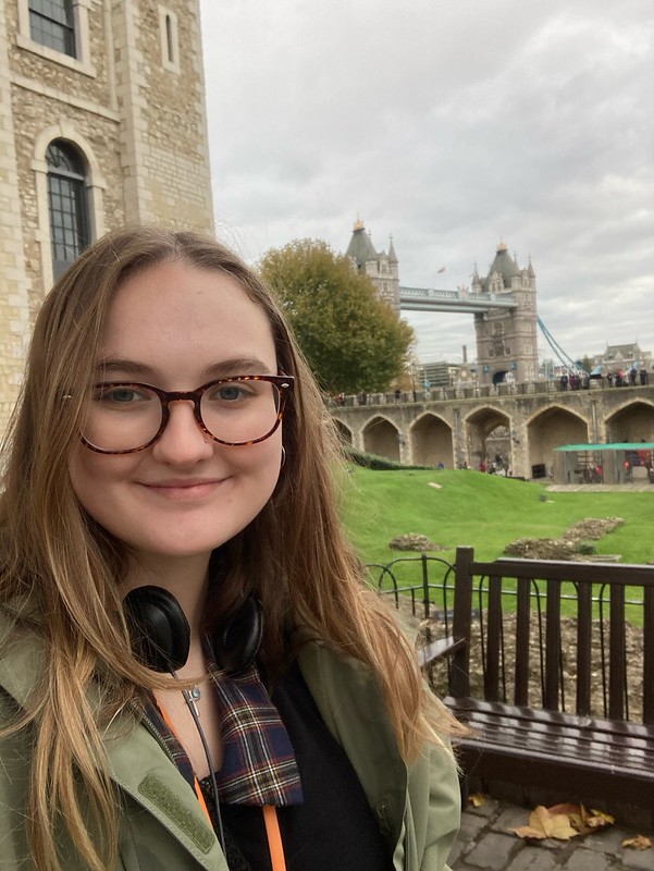 Macy smiling in front of the Tower of London with the Tower Bridge in the background. 