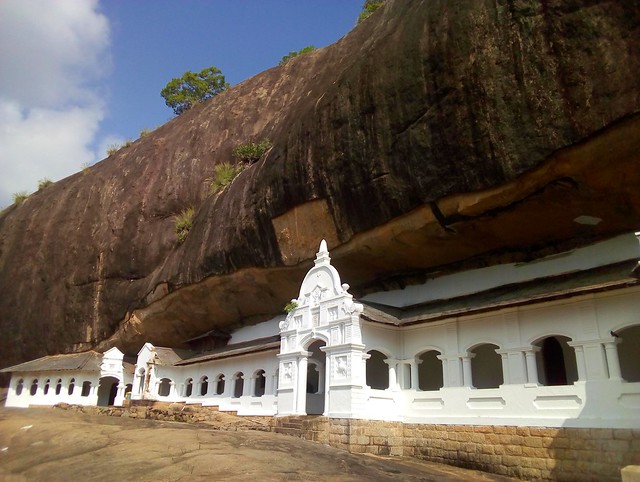 Dambulla is really more of a large rock overhang than a cave.  The overhang has been closed off with walls so it's a series of rooms fulls of stautes and paintings on the ceilings and walls. by bryandkeith on flickr