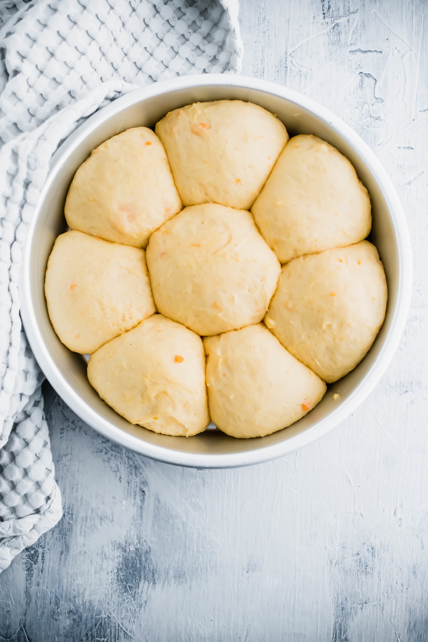 8 risen sweet potato rolls in round cake pan.