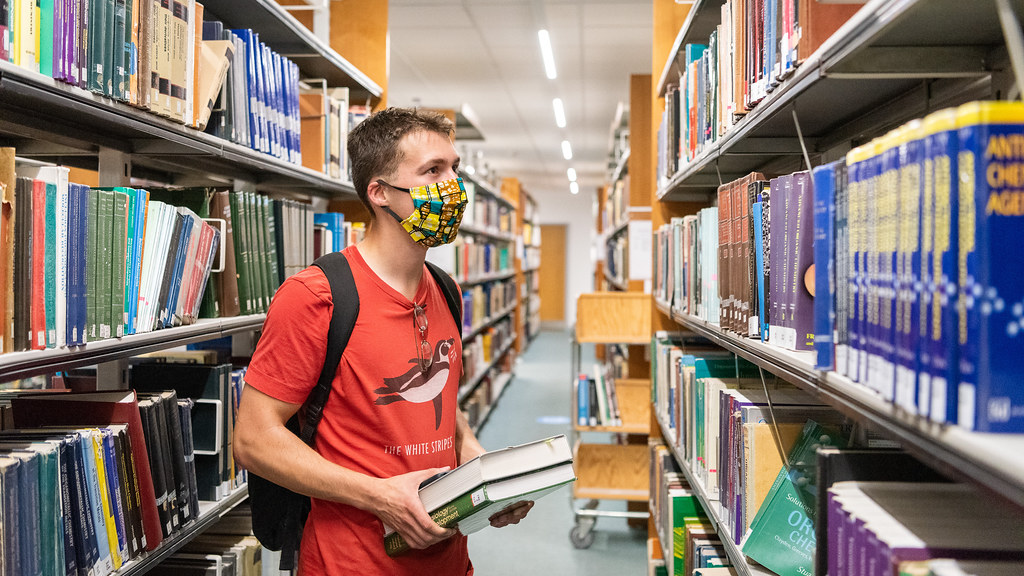 A student wearing a face mask in the Library.