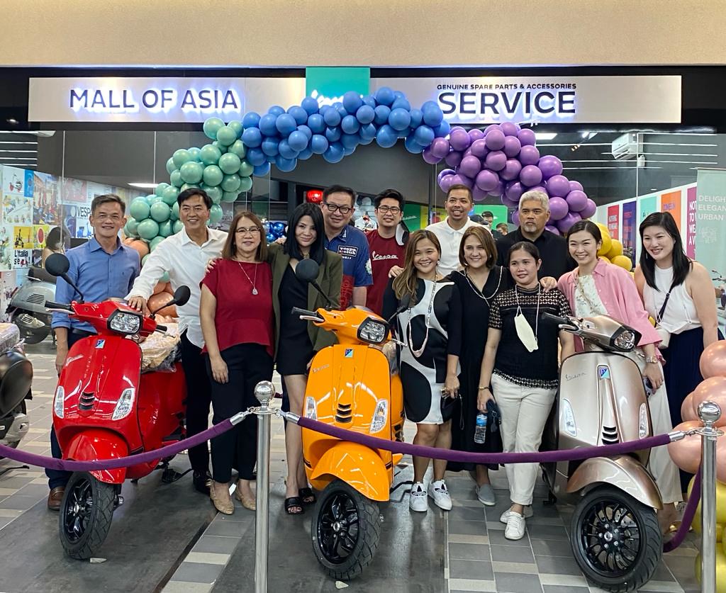 A group of people posing for a photo with toy scooters

Description automatically generated with medium confidence