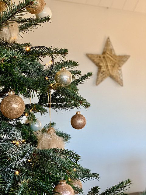 Kerstboom met gouden ballen rotan ster aan de muur