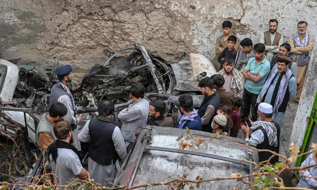 美軍無人機襲擊造成十名阿富汗平民死亡，受害者親友聚集在遭攻擊的汽車旁。（圖片來源：衛報）