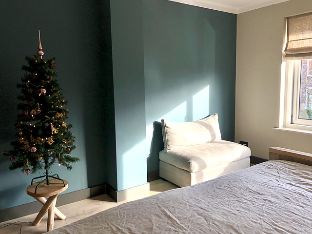 Groene muur slaapkamer stoel zonder leuning mini kerstboom op houten krukje