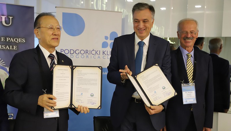 Le Dr. Katsumi Otsuka et S.E. Filip Vujanović tenant les copies signées du Mémorandum of Coopération. 
à droite : M. Ruzdija Tuzovic, secrétaire général du Club Podgorica.