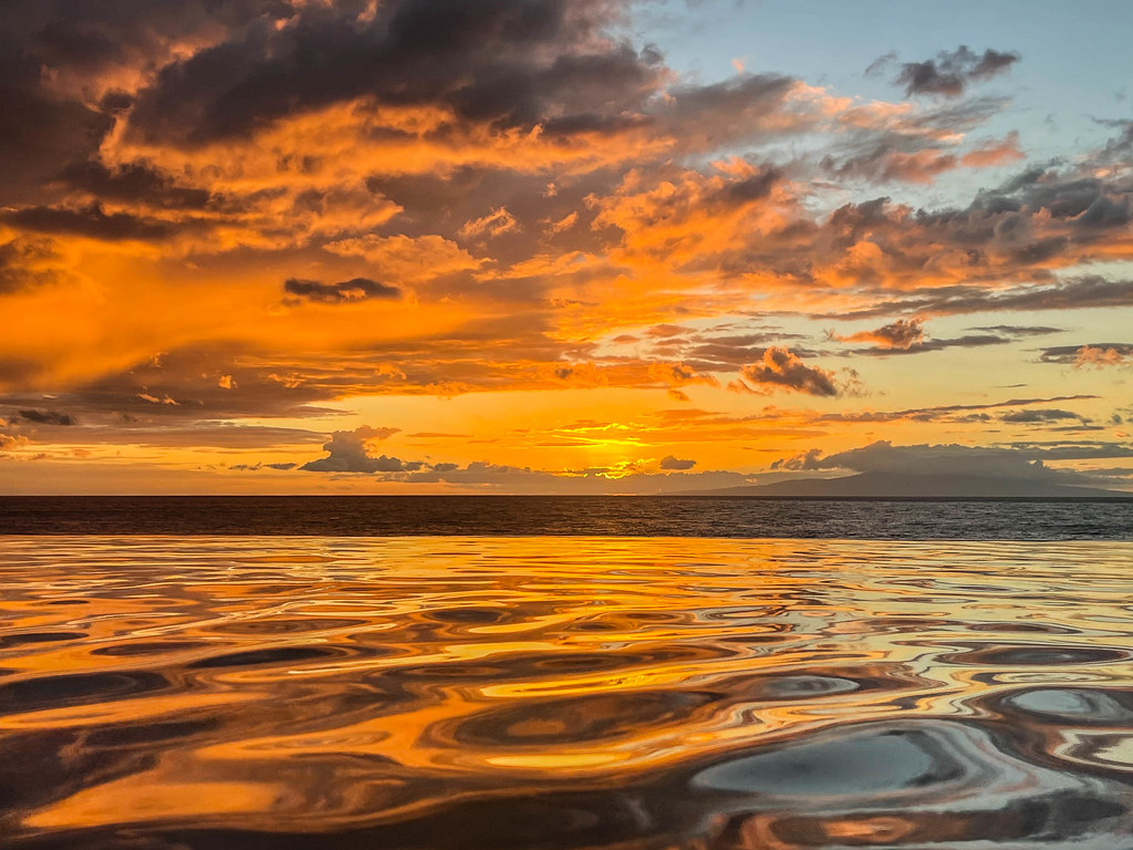 Golden sunset reflected on calm ocean water off Wailea, Maui