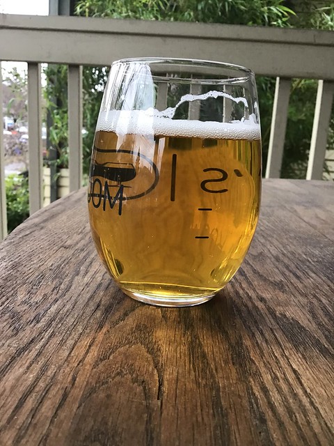 Drinking the Cup of Judgment hoppy pils from Holy Mountain brewery, in glass outside on table. 