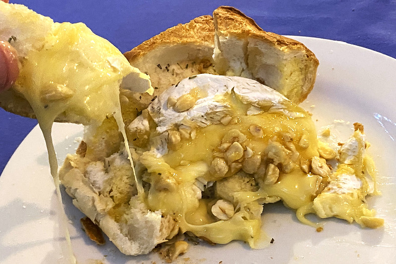 Baked brie in bread with hazelnuts and honey