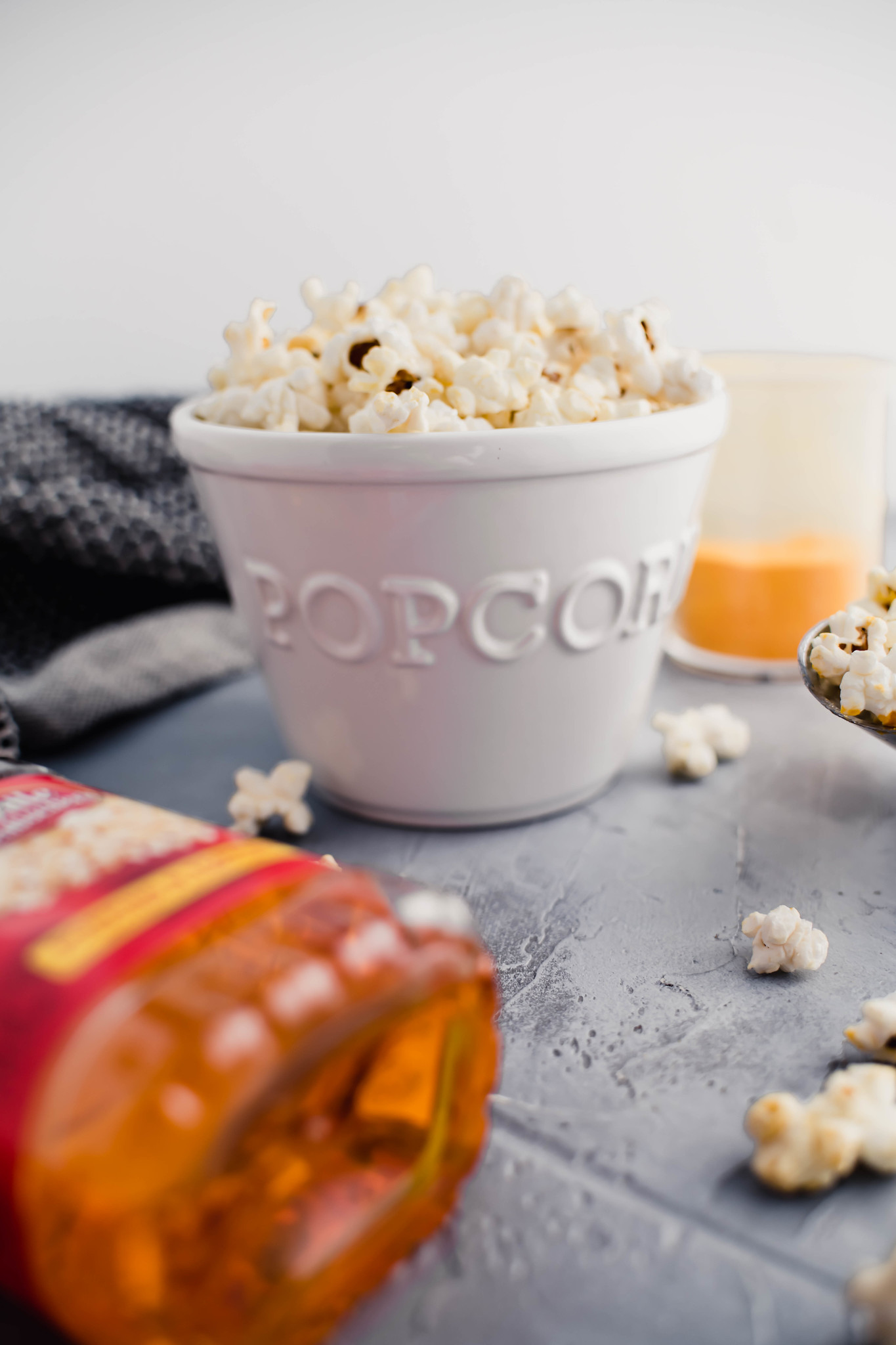 White ceramic bowl that says popcorn, filled with popcorn.