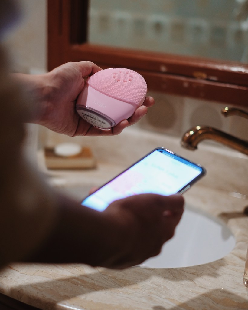 Woman holding Foreo Luna 3 Plus and Mobile phone 