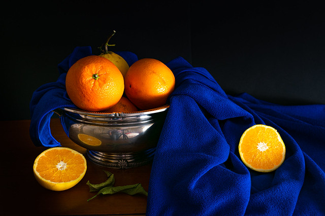 Bodegón clásico con naranjas y tela azul