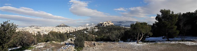 Athens panoramic view in snow, from Pnika (Pnyx) hill, towards hills of Acropolis, Lycabettus and mountain Hymettus in background, white dressed