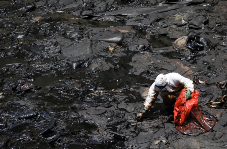 工人在海灘清理油污。（圖片來源：Al Jazeera）