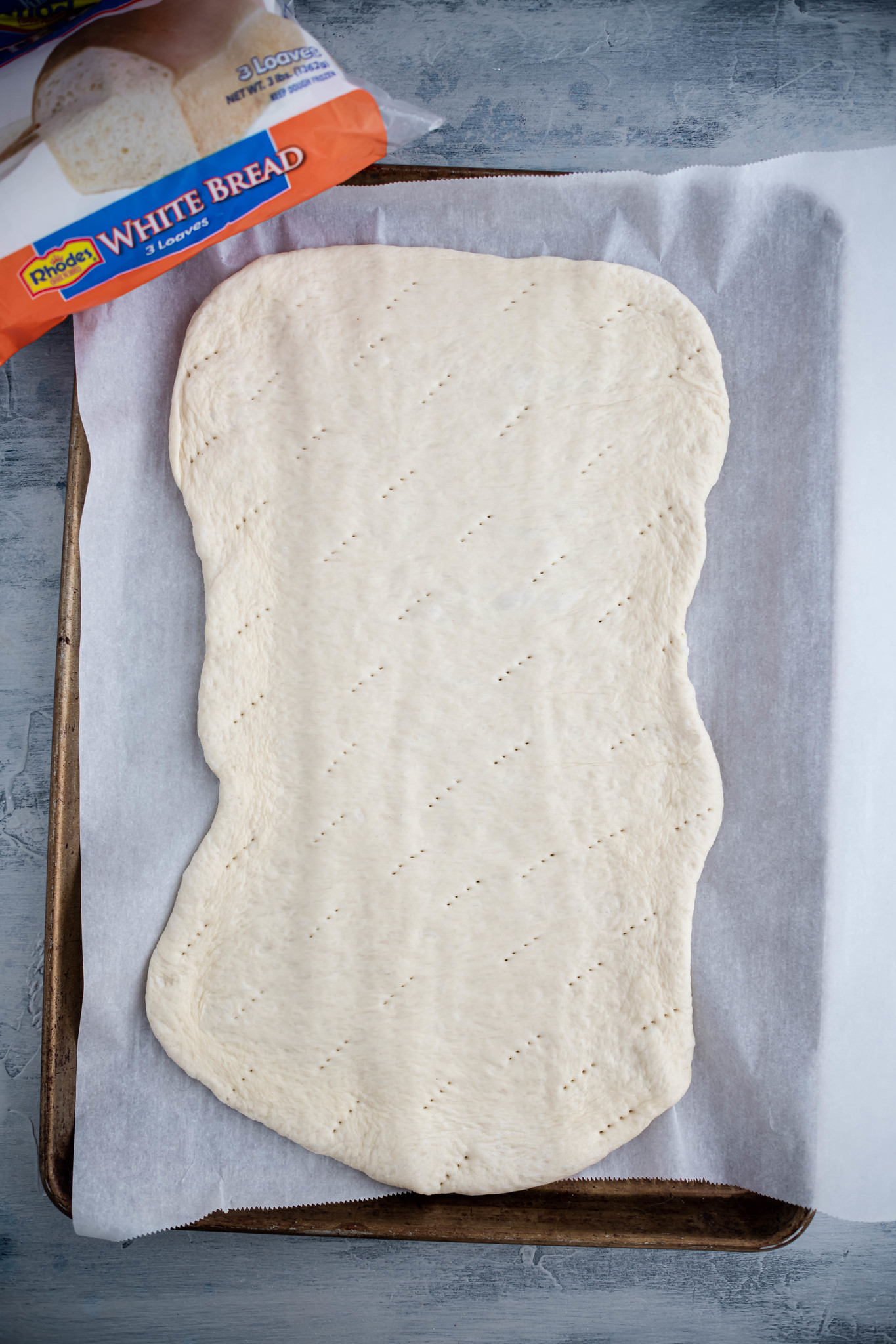 Bread dough pressed out into a rectangle and pricked all over with a fork.