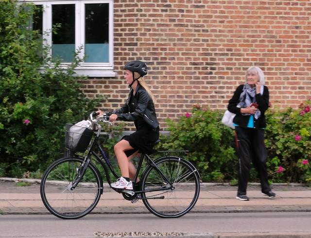 Copenhagen old girl watches a cyclist pass