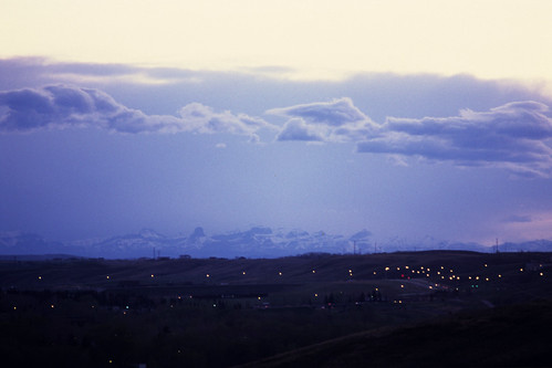 Bowness Sunset 5: Purple Mountains by pmvarsa, Sunset over Bowness in Calgary, Alberta, Canada.

Distant mountains are framed by clouds over Bownes