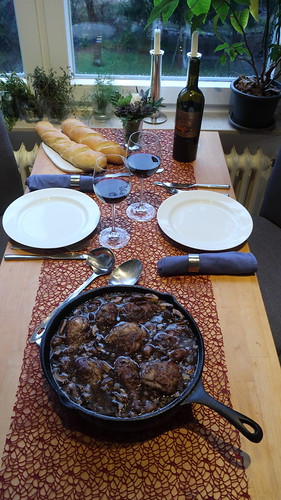 Coq au vin mit frisch gebackenem Baguette (Tischbild)