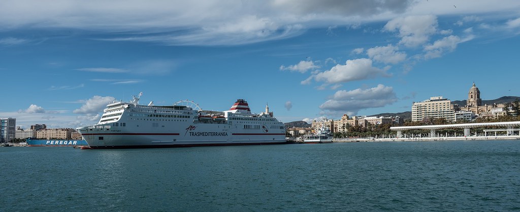 A panoramic view of the touristic harbour in Malaga. On the left hand side there is a big ship, a ferry crossing over to Morocco.
