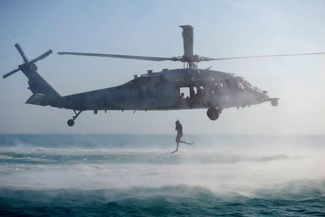 A diver with international maritime forces participating in helicopter insertion and extraction training in the Arabian Gulf.