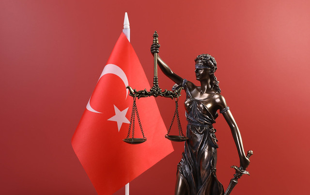 Statue of Lady Justice and flag of Turkey on red background