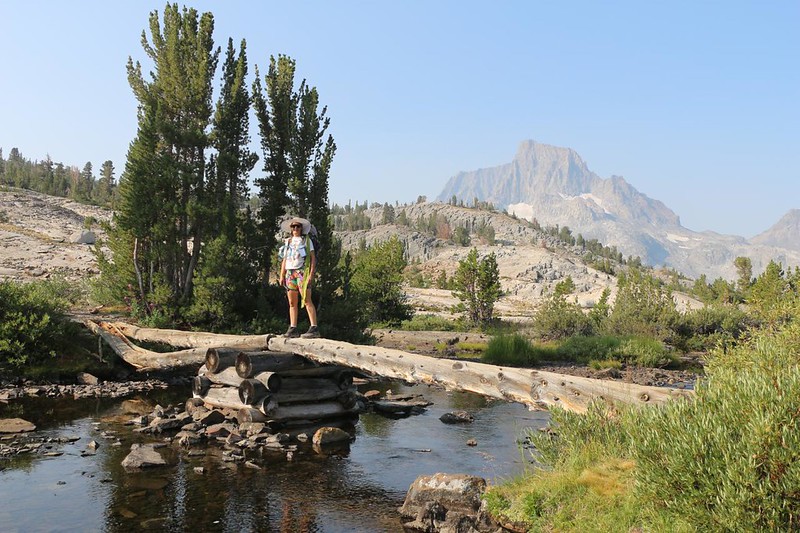 Vicki posing on the footbridge at Thousand Island Lake on the JMT, crossing the Middle Fork San Joaquin River