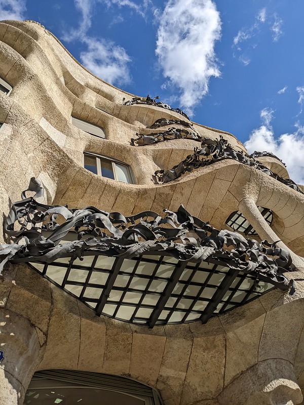 Looking up at the balconies of the Casa Mila in the blue sky