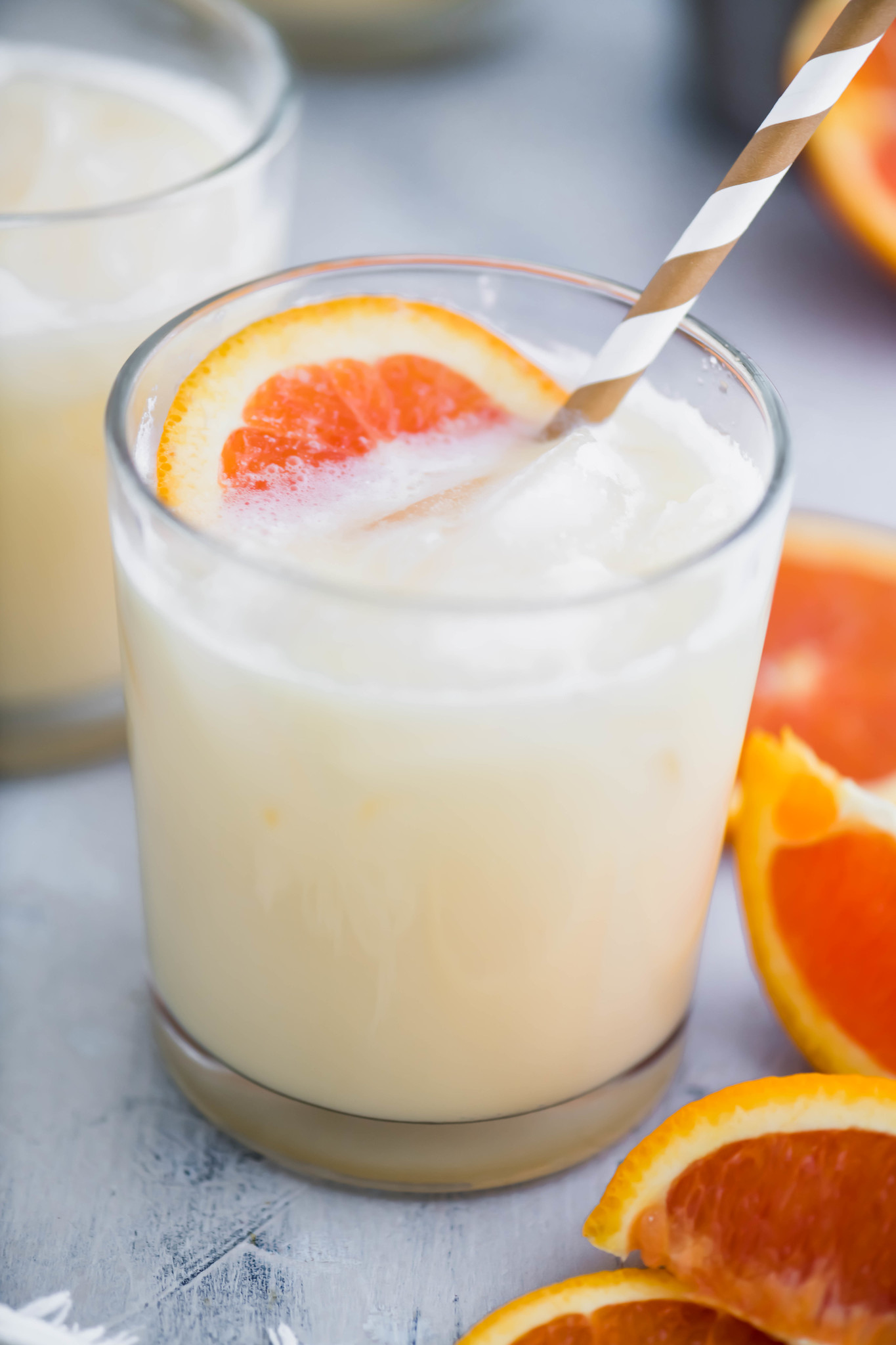 Cocktail glass filled with creamsicle cocktail with an orange slice floating in the glass.