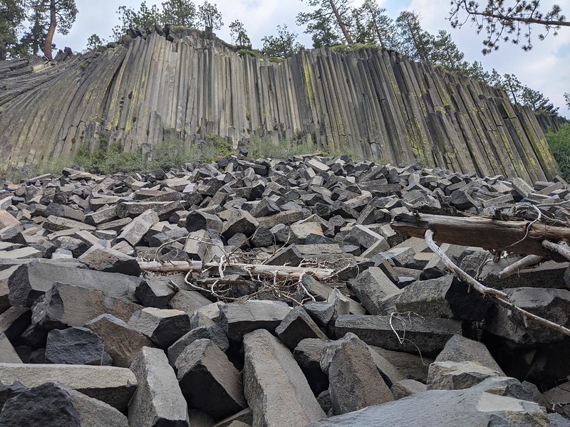 Vertical basalt columns and tumbled broken stones down below them at the Devils Postpile