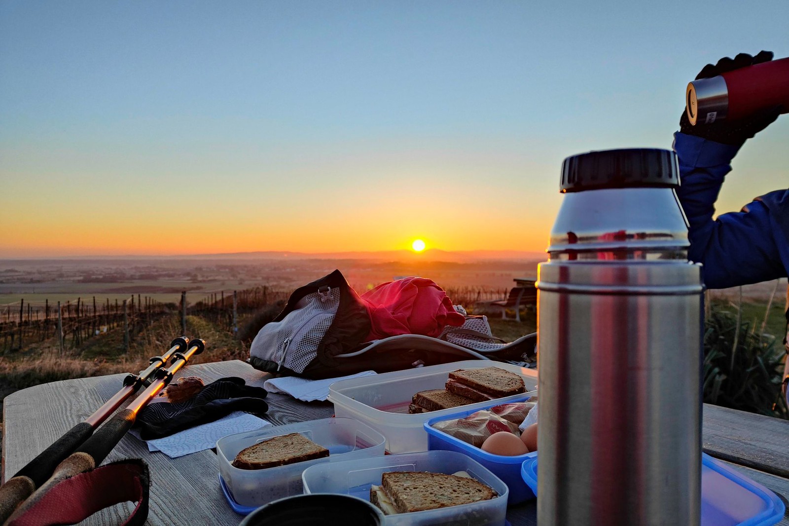 Frühstück bei Sonnenaufgang am Tisch des Weines bei Hangen-Wahlheim mit Blick auf Rheintal und Odenwald im Osten