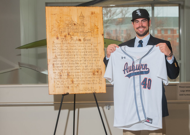 Bo Plagge holding an Auburn baseball jersey.