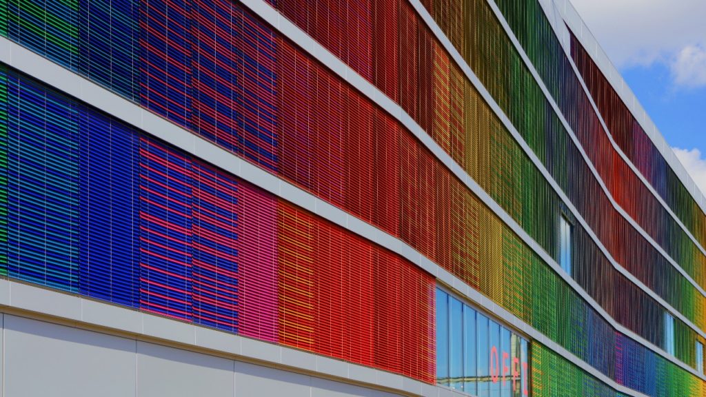 An office building decorated with rainbow coloured slats 
