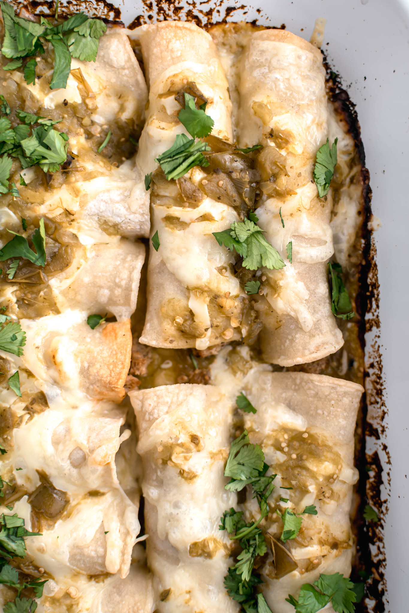Close up photo of enchiladas in a 13x9 pan.