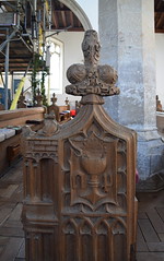 chalice and host bench end with part of winged bull of St Luke