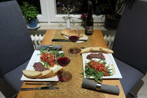 Rehrücken mit Tomaten, Ruccola und Weißbrot (Tischbild)
