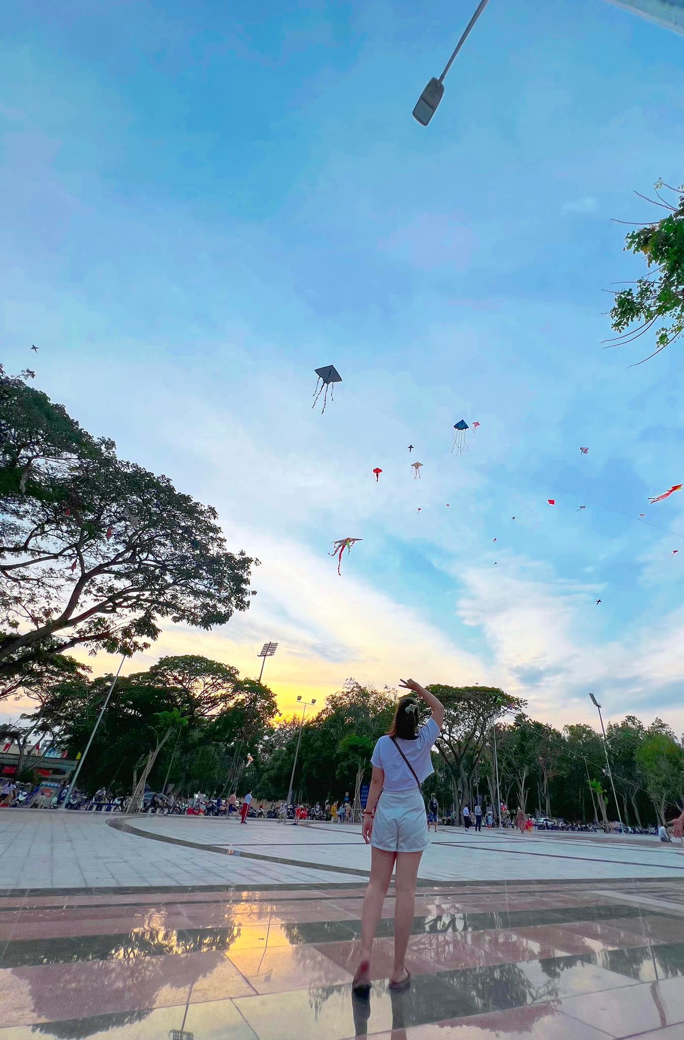 Một bạn gái tạo dáng cũng những cánh diều đang bay ở Bãi Cát (Ninh Kiều)