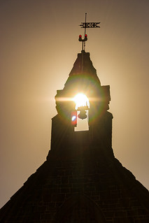 Silhouette of old church in Bulla Victoria with sunset glinting through the bell tower