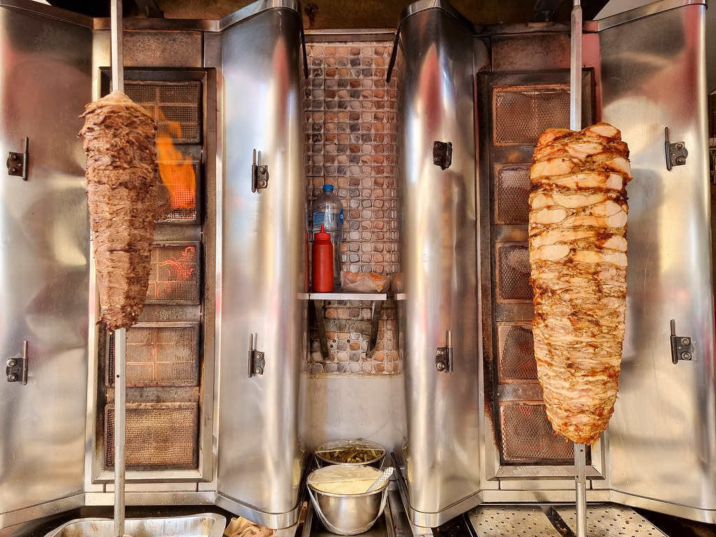 Two vertical rotisserie, one with beef meat and one with chicken
