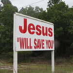 Jesus "Will Save You" Photographed on North Carolina Highway 211 in Hoke County near Zack&#039;s Grocery and Grill and a sand pit. I am not sure the people who put up the sign understand the possible ironic use of the quotations marks.                    