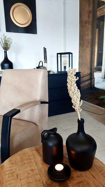 Landelijk chique woonkamer fauteuil leer zwarte vazen dressoir zwart
