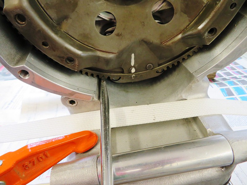 Large Blade Screwdriver In Flywheel Teeth To Keep Engine From Rotating