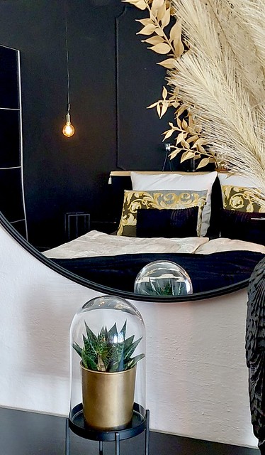 Hotel stijl slaapkamer zwart met goud ronde spiegel cactus onder stolp