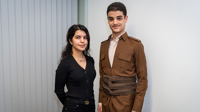Ahmad, wearing a tan brown Kurdish outfit, stood next to Melissa who is wearing all black clothing